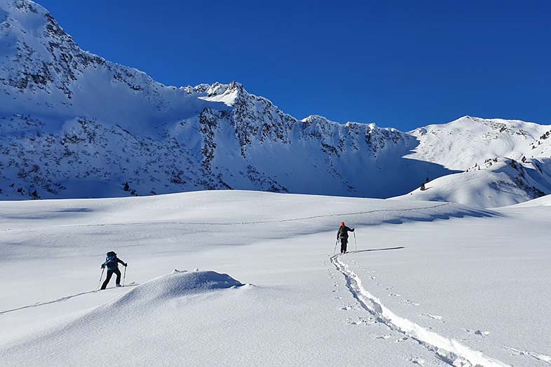 2-menschen-beim-schneeschuhwandern-auf-verschneitem-berg